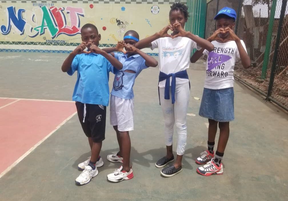 Four children making heart signs with their hands